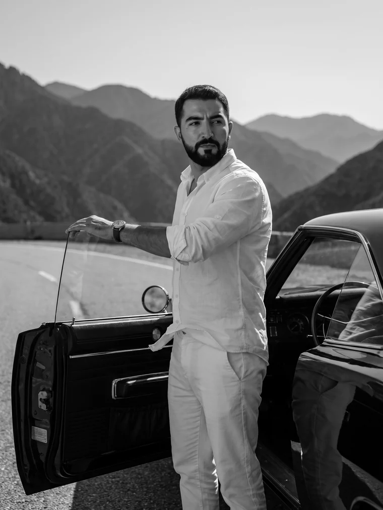 Black and white, standing by the open door on a mountain road